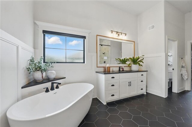 17316 Noland St, Overland Park, KS 66221 - bathroom with a soaking tub, vanity, tile patterned flooring, and wainscoting