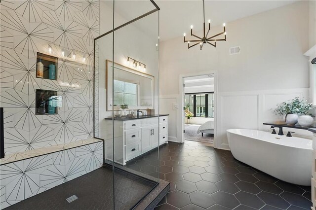 17316 Noland St, Overland Park, KS 66221 - ensuite bathroom with a high ceiling, a soaking tub, a chandelier, vanity, and a tile shower