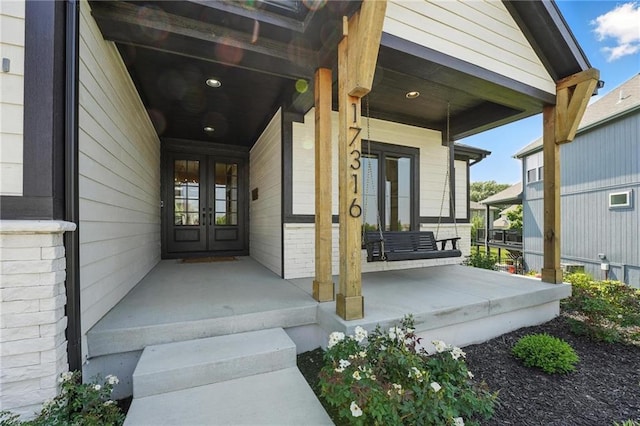 17316 Noland St, Overland Park, KS 66221 - doorway to property with french doors, covered porch, and brick siding