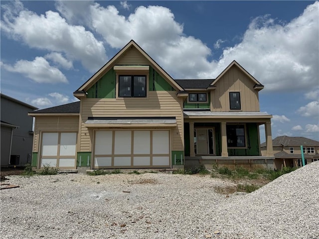 12400 W 184th St, Overland Park, KS 66013 - view of front of home featuring covered porch, board and batten siding, a garage, and gravel driveway