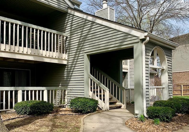 8806 W 106th Ter, Overland Park, KS 66212 - view of side of home with a balcony, a chimney, and stairs