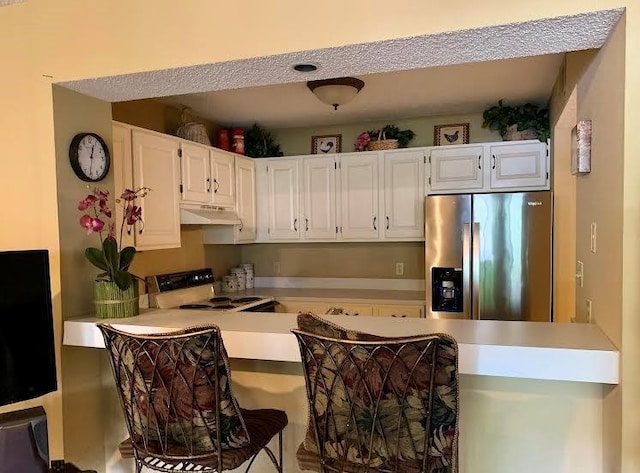 8806 W 106th Ter, Overland Park, KS 66212 - kitchen featuring stainless steel fridge, range with electric cooktop, under cabinet range hood, a peninsula, and white cabinets