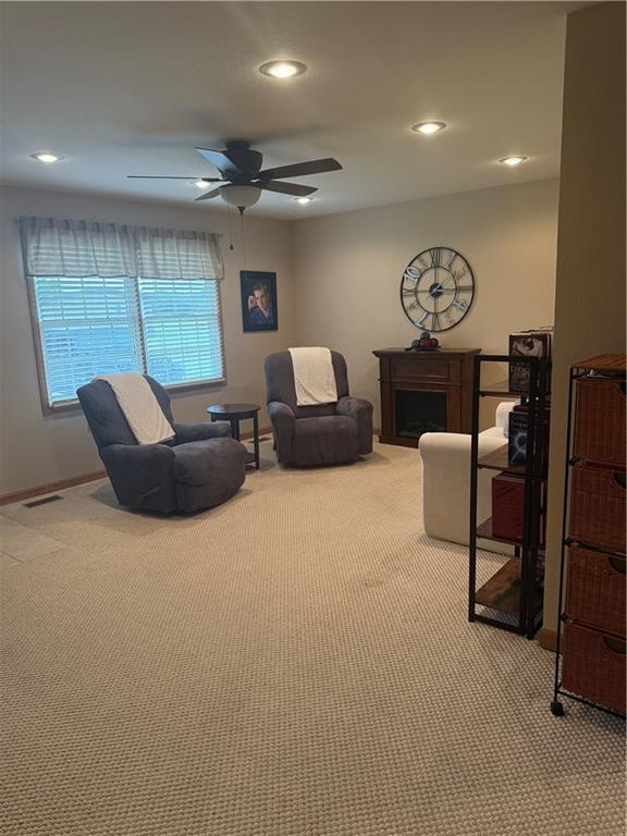 1003 S Ridgeway St, Caney, KS 67333 - living room with light carpet, a ceiling fan, recessed lighting, and a fireplace