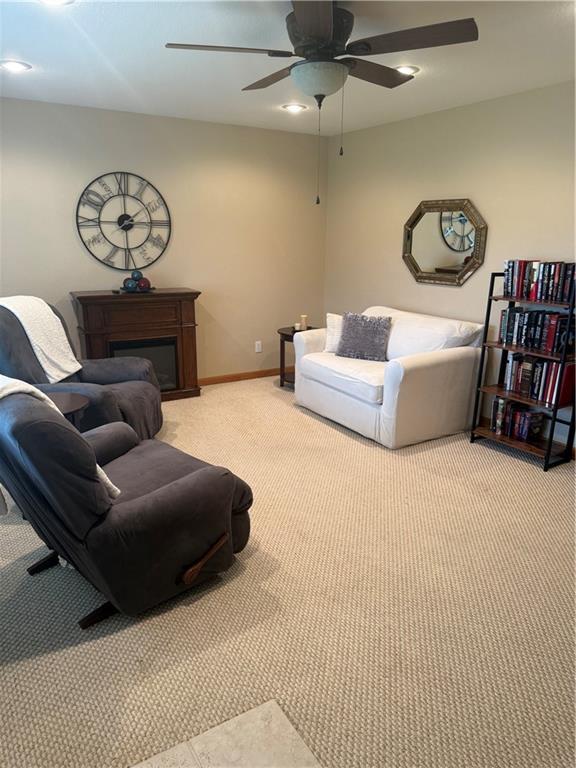 1003 S Ridgeway St, Caney, KS 67333 - living area featuring light carpet, a ceiling fan, and a fireplace