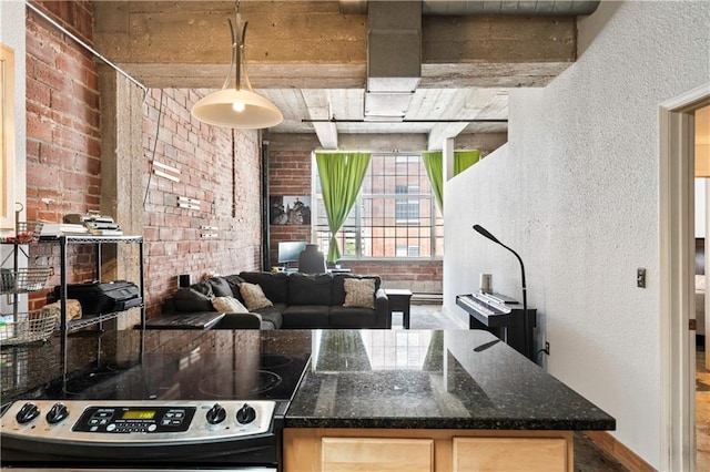 321 W 7th St Unit 501, Kansas City, MO 64105 - kitchen with range, light brown cabinetry, brick wall, and a textured wall
