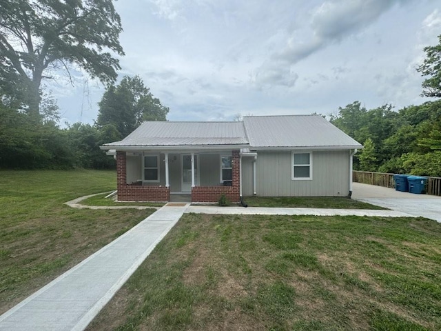 11828 E Roberts St, Sugar Creek, MO 64054 - view of front of home featuring a front lawn, a metal roof, a porch, and brick siding