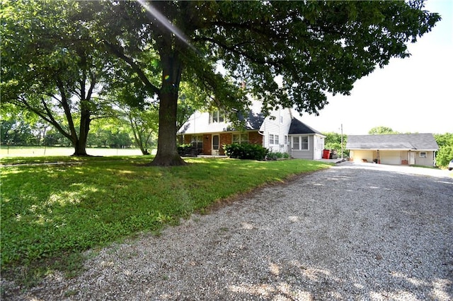 31212 E Webster Rd, Grain Valley, MO 64029 - view of front of property featuring gravel driveway, brick siding, a garage, and a front yard
