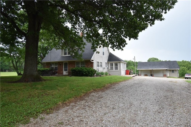 31212 E Webster Rd, Grain Valley, MO 64029 - cape cod home featuring gravel driveway, a front lawn, and an outbuilding