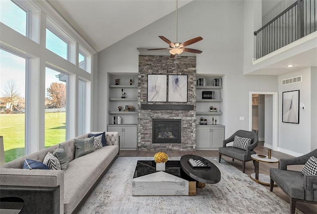 19787 W 114th Pl, Olathe, KS 66061 - living area featuring high vaulted ceiling, a ceiling fan, wood finished floors, built in features, and a fireplace