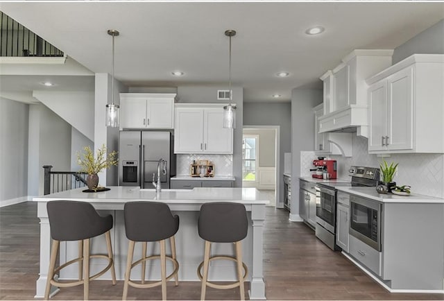 19787 W 114th Pl, Olathe, KS 66061 - kitchen featuring stainless steel appliances, light countertops, backsplash, a kitchen island with sink, and recessed lighting