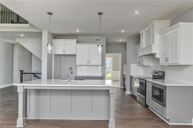 19787 W 114th Pl, Olathe, KS 66061 - kitchen featuring stainless steel appliances, light countertops, a center island with sink, white cabinetry, and recessed lighting
