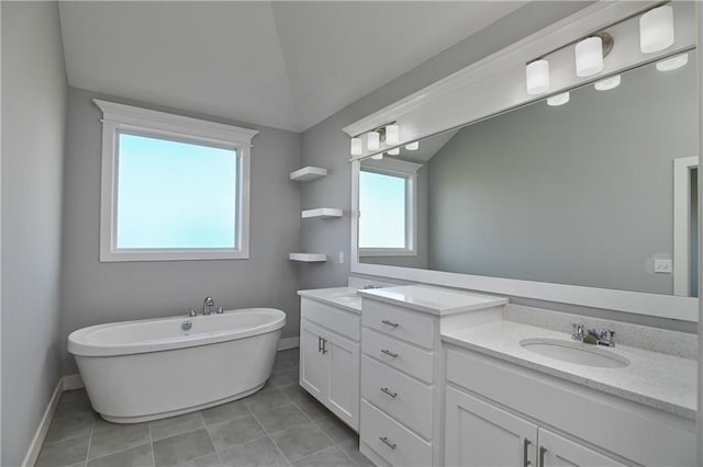 19787 W 114th Pl, Olathe, KS 66061 - full bathroom with double vanity, healthy amount of natural light, a freestanding bath, vaulted ceiling, and tile patterned floors
