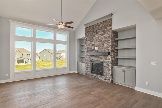 19787 W 114th Pl, Olathe, KS 66061 - unfurnished living room with a ceiling fan, dark wood finished floors, a stone fireplace, high vaulted ceiling, and built in shelves