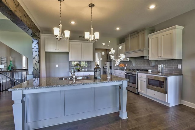 19787 W 114th Pl, Olathe, KS 66061 - kitchen with stainless steel appliances, a chandelier, white cabinets, dark stone countertops, and decorative backsplash