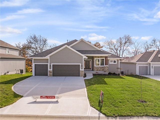19499 W 114th Ter, Olathe, KS 66061 - view of front of house featuring stone siding, driveway, a garage, and a front yard
