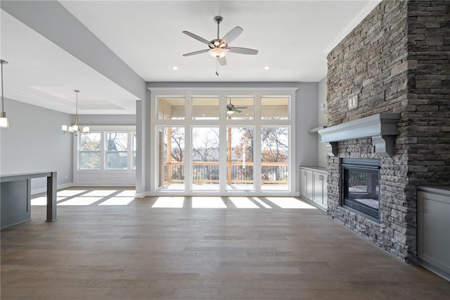 19499 W 114th Ter, Olathe, KS 66061 - unfurnished living room featuring a ceiling fan, a fireplace, wood finished floors, a chandelier, and recessed lighting