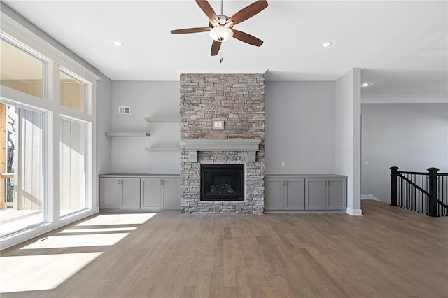 19499 W 114th Ter, Olathe, KS 66061 - unfurnished living room featuring a ceiling fan, wood finished floors, a stone fireplace, and recessed lighting