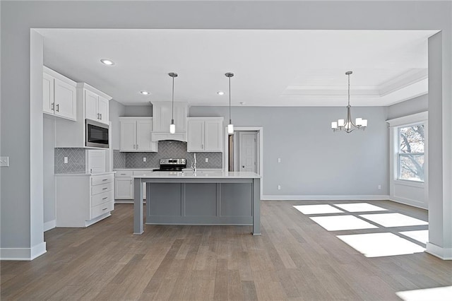 19499 W 114th Ter, Olathe, KS 66061 - kitchen with appliances with stainless steel finishes, light wood-type flooring, white cabinetry, decorative backsplash, and light countertops