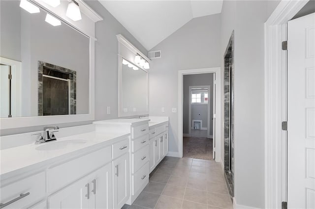 19499 W 114th Ter, Olathe, KS 66061 - bathroom featuring double vanity, lofted ceiling, a shower stall, and tile patterned flooring