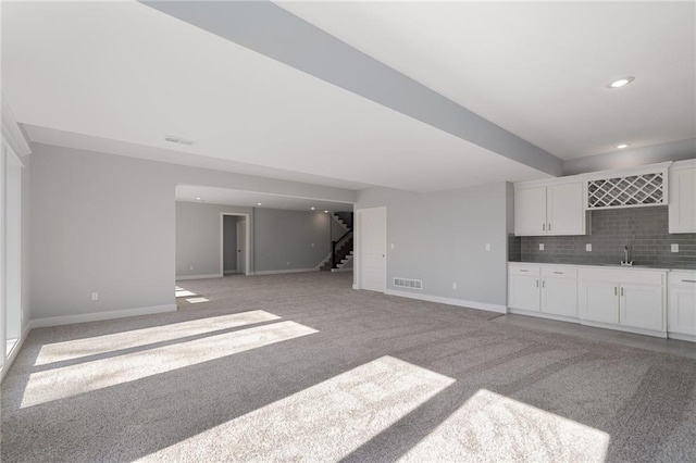 19499 W 114th Ter, Olathe, KS 66061 - unfurnished living room featuring wet bar, stairway, light colored carpet, and recessed lighting
