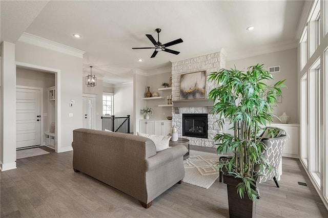 19499 W 114th Ter, Olathe, KS 66061 - living room with ceiling fan, a stone fireplace, recessed lighting, crown molding, and wood finished floors