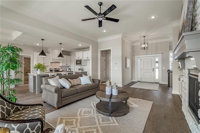 19499 W 114th Ter, Olathe, KS 66061 - living area featuring dark wood-style floors, crown molding, a ceiling fan, recessed lighting, and a chandelier