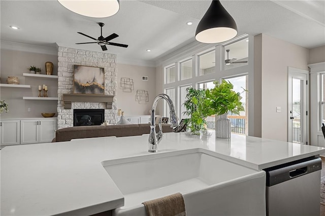 19499 W 114th Ter, Olathe, KS 66061 - kitchen featuring ceiling fan, crown molding, stainless steel dishwasher, light countertops, and a fireplace