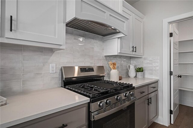 19499 W 114th Ter, Olathe, KS 66061 - kitchen featuring stainless steel gas stove, custom range hood, decorative backsplash, dark wood finished floors, and white cabinets