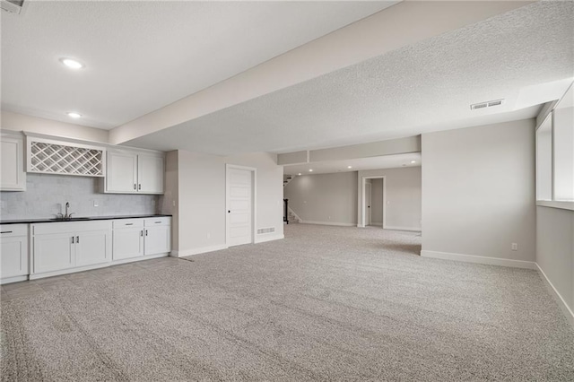 19499 W 114th Ter, Olathe, KS 66061 - interior space with wet bar, light colored carpet, stairs, recessed lighting, and a textured ceiling