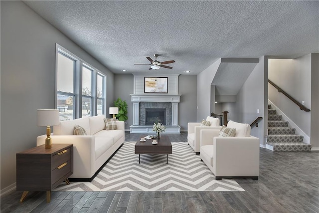 19444 W 114th Ter, Olathe, KS 66061 - living room with a textured ceiling, wood finished floors, a ceiling fan, stairway, and a fireplace