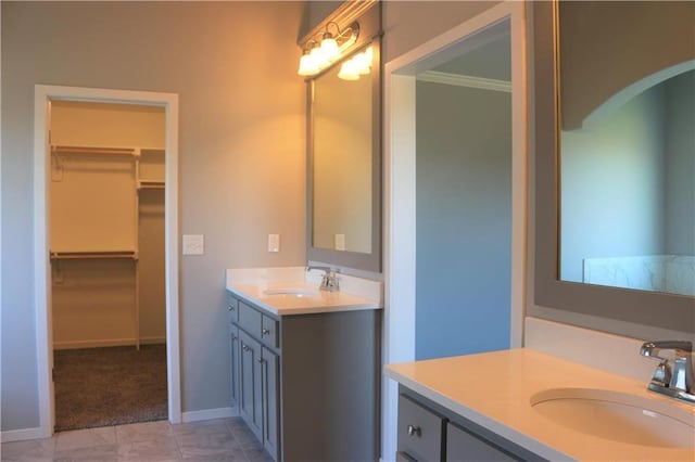 19444 W 114th Ter, Olathe, KS 66061 - bathroom featuring two vanities, a spacious closet, and ornamental molding