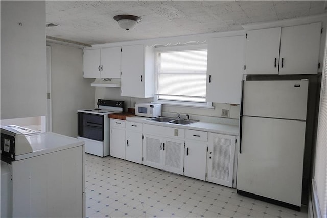 1101 S Broadway St, Leavenworth, KS 66048 - kitchen with white appliances, under cabinet range hood, washer / clothes dryer, light flooring, and white cabinetry
