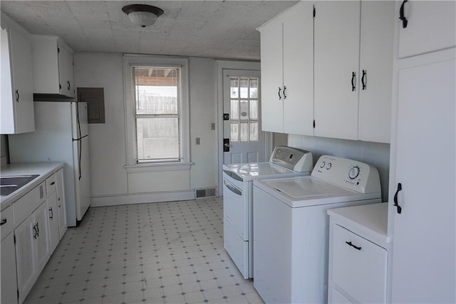 1101 S Broadway St, Leavenworth, KS 66048 - washroom featuring washing machine and dryer, light floors, and cabinet space