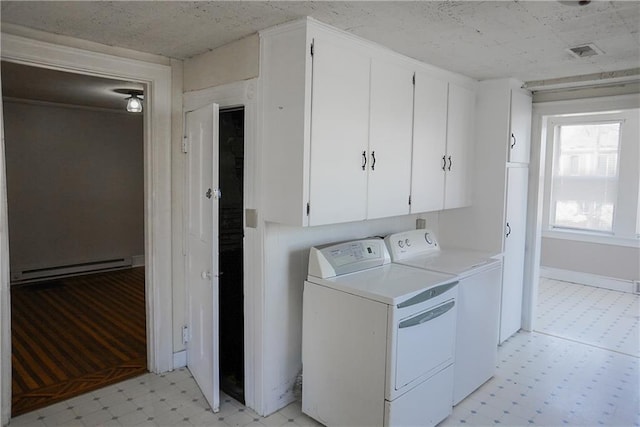 1101 S Broadway St, Leavenworth, KS 66048 - laundry room featuring washing machine and clothes dryer, light floors, a baseboard radiator, and cabinet space