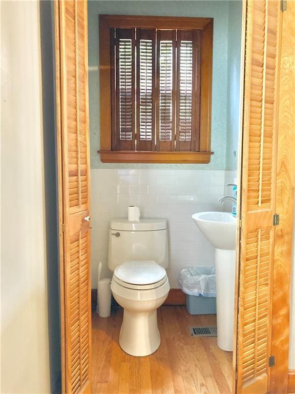 406 S 6th St, Burlington, KS 66839 - bathroom featuring wood finished floors, wainscoting, tile walls, and a closet