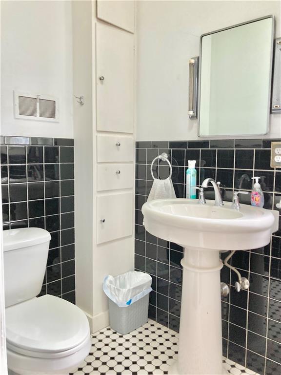 406 S 6th St, Burlington, KS 66839 - bathroom with tile walls, tile patterned flooring, and wainscoting