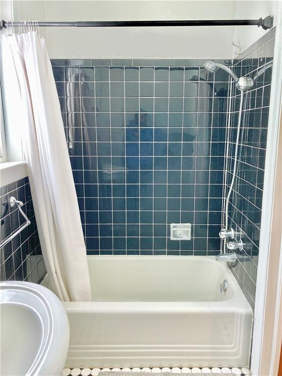 406 S 6th St, Burlington, KS 66839 - bathroom featuring shower / bath combo and tile walls
