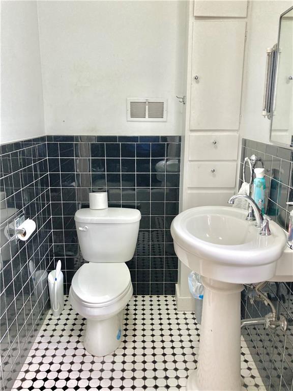 406 S 6th St, Burlington, KS 66839 - bathroom featuring tile walls, wainscoting, and tile patterned floors