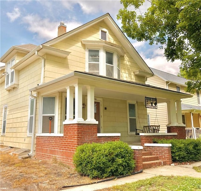 406 S 6th St, Burlington, KS 66839 - view of front of home with a porch, a chimney, and brick siding