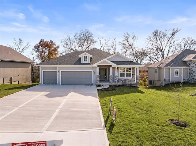 19455 W 114th Ter, Olathe, KS 66061 - craftsman-style home with a garage, concrete driveway, a front lawn, stone siding, and a shingled roof
