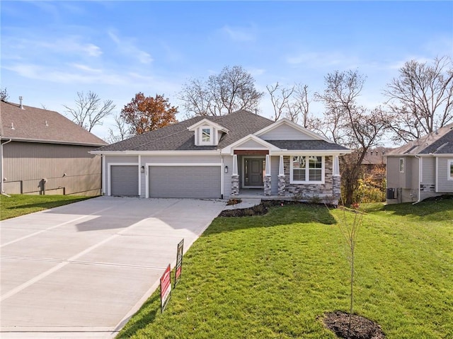 19455 W 114th Ter, Olathe, KS 66061 - view of front of house featuring an attached garage, a front lawn, concrete driveway, roof with shingles, and stone siding