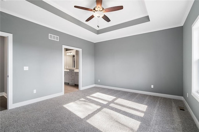 19455 W 114th Ter, Olathe, KS 66061 - unfurnished bedroom featuring light carpet, a tray ceiling, connected bathroom, crown molding, and a ceiling fan