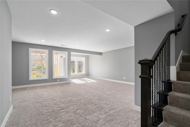 19455 W 114th Ter, Olathe, KS 66061 - unfurnished living room featuring carpet flooring, stairs, a textured ceiling, and recessed lighting