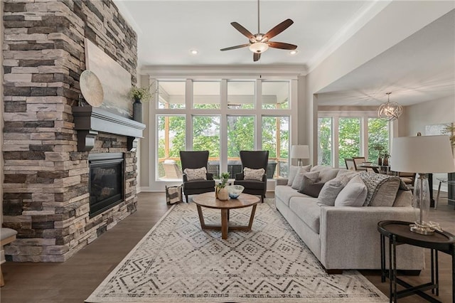 19345 W 114th Ter, Olathe, KS 66061 - living area featuring plenty of natural light, a fireplace, a ceiling fan, wood finished floors, and crown molding