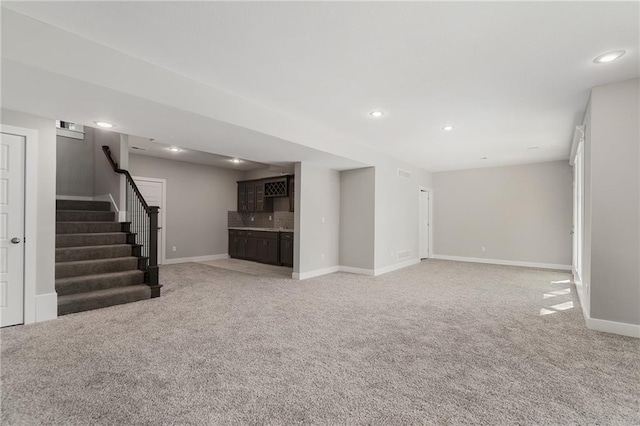 19345 W 114th Ter, Olathe, KS 66061 - unfurnished living room with bar, stairs, light carpet, and recessed lighting