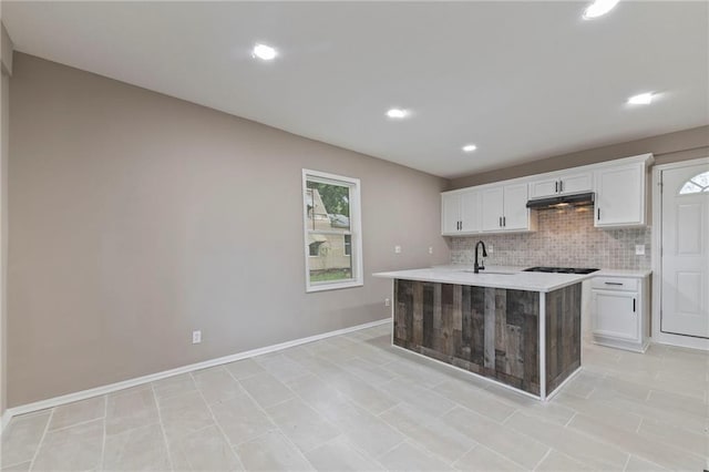 605 Oak St, Leavenworth, KS 66048 - kitchen with light countertops, white cabinetry, decorative backsplash, recessed lighting, and under cabinet range hood