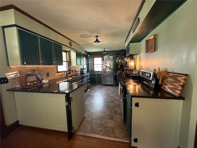 3112 N 155th St, Basehor, KS 66007 - kitchen with a peninsula, a textured ceiling, dark countertops, stainless steel appliances, and tasteful backsplash