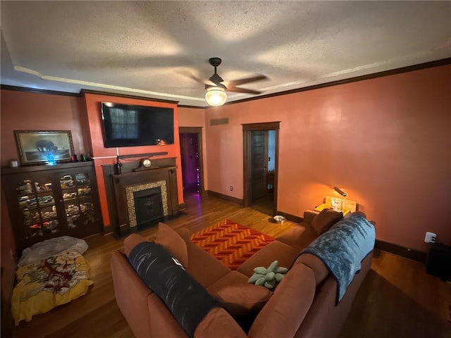 3112 N 155th St, Basehor, KS 66007 - living room with wood finished floors, a textured ceiling, a ceiling fan, a fireplace, and crown molding