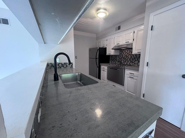 419 W 104th St Unit D, Kansas City, MO 64114 - kitchen with stainless steel gas range, freestanding refrigerator, under cabinet range hood, backsplash, and white cabinets