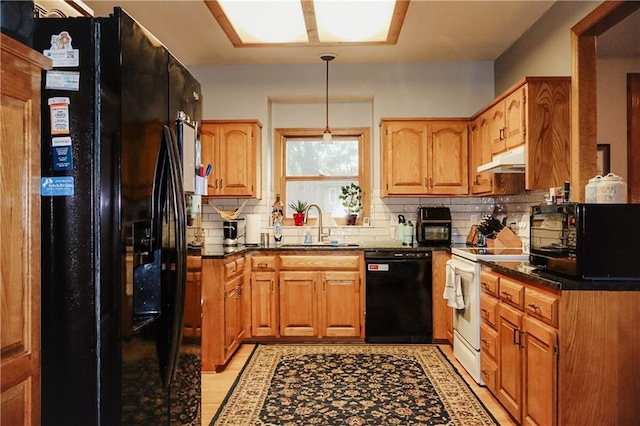 11669 S Parkwood Dr, Olathe, KS 66061 - kitchen featuring black appliances, under cabinet range hood, backsplash, dark countertops, and hanging light fixtures